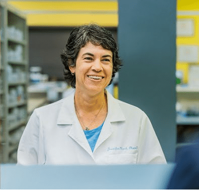 Pharmacist smiling while helping a customer.